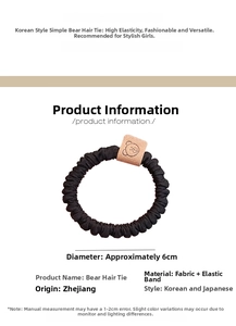 Close-up of black elastic hair tie featuring a brown leather bear tag decoration