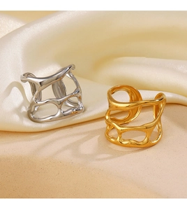 Detail shot of gold and silver irregular hollow rings on elegant cream silk fabric