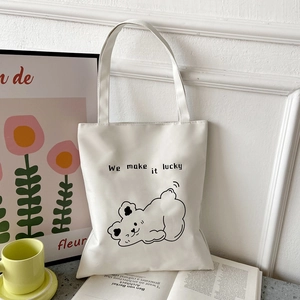 Detail of white Oxford tote bag with black bear illustration and lucky text slogan