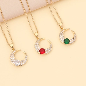 Detailed shot of crescent moon necklaces with red, green and clear zircon stones