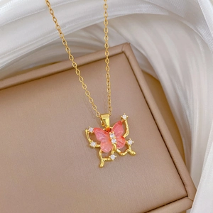 Macro detail of gold butterfly pendant with pink crystals and sparkling diamond edges