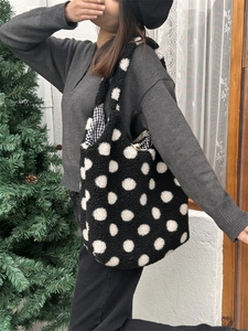 Gros plan du sac seau noir à pois en peluche porté par un mannequin en hiver doux
