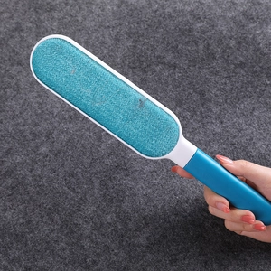 Portable blue static lint remover brush for pet hair and clothing on a fabric surface