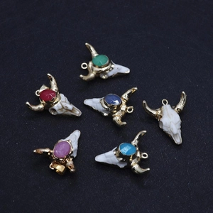 Macro detail of bull head resin pendants with colorful stones and gold plated horns
