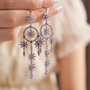 Detail showing purple zircon flower tassel earrings with silver finish and crystal accents