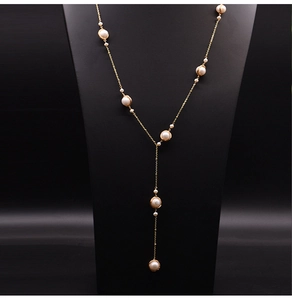 Detailed view of handmade freshwater pearl necklace with gold wire wrap on a black mannequin
