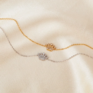 French style stainless steel bracelet with diamond-encrusted crown pendant on silk