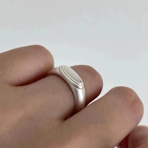 Silver minimalist ring with white shell inlay shown on hand against white background