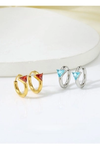 Detailed macro of gold and silver geometric earrings with colorful triangle zircons