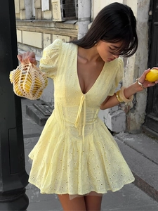 Detail of yellow cotton dress with lace embroidery, deep V-neck and puff sleeves design