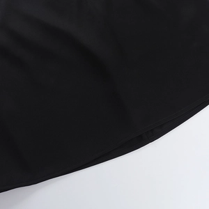 Detail view of double stitching on the hem of a black bodycon halter dress