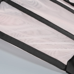 Macro detail of breathable pink mesh and black satin trim on a structured corset dress