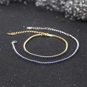 Macro detail of 2mm tennis bracelets in gold and silver plating with blue zircons