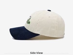 Detail of corduroy baseball cap featuring navy brim and side letter embroidery