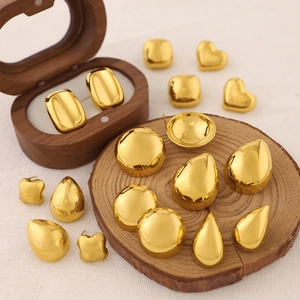 Chic 18K gold teardrop and heart stud earrings set on wooden display accessories