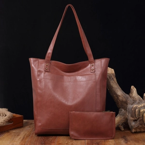 Détail d'un sac cabas en cuir vintage marron avec poche avant et pochette assortie