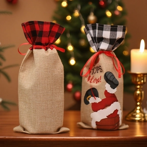 Linen Christmas wine bottle bags with Santa Claus and red plaid design on wooden table