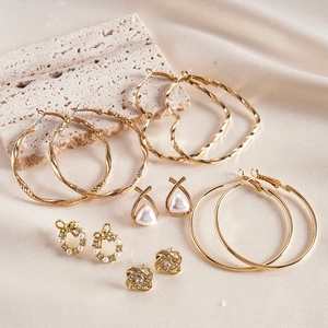 Détail du lot de 6 paires de boucles d'oreilles dorées avec perles sur soie beige