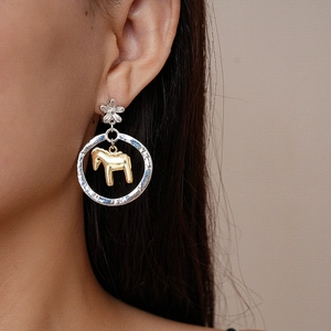 Dettaglio orecchino a fiore argento con ciondolo a cavallo dorato indossato da modella