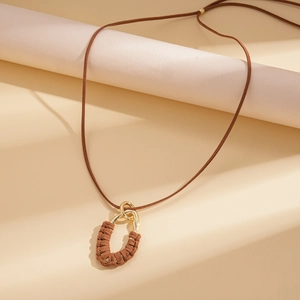 Detail of bohemian long necklace with interlocking gold metal and brown velvet oval rings