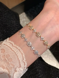 Close-up of 18K gold and silver plated adjustable bracelets with zircon floral charms