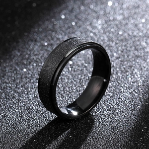 Detail shot of 6mm matte black titanium steel ring with polished edges on dark surface