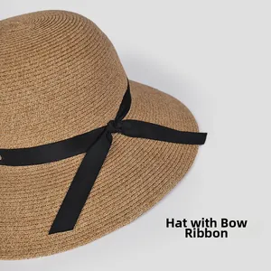 Detail of hand-woven straw sun hat showing the texture of black grosgrain ribbon bow