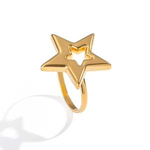 Détail de la finition dorée polie et du design d'étoile évidée sur la bague en acier