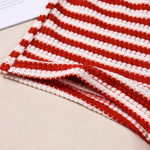 Gros plan détaillé du tissu en maille rayé rouge et blanc montrant la texture de tissage