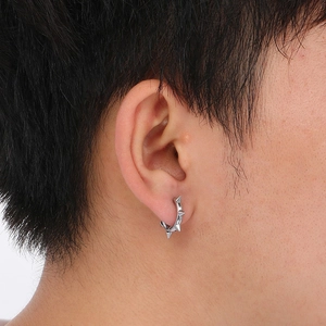 Close-up of silver stainless steel Mobius hoop earring with punk spike studs on ear