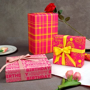 Pink and yellow birthday gift wrapping paper rolls with floral and grid patterns