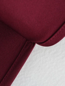 Détail d'un haut bordeaux à épaulettes montrant la texture plissée et les coutures