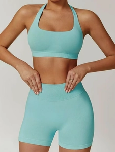 Detail of mint blue seamless ribbed yoga set showing high waist shorts and halter neck top