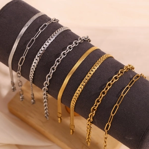 Dettaglio di bracciali a serpente, a graffetta e a catena cubana in oro e argento