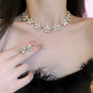 Close-up of sparkling floral diamond necklace and ring set on model for luxury look
