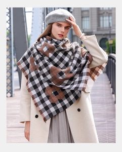 Detail of soft black and white checkered scarf with brown floral patterns and fringe trim