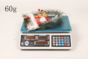 Detailansicht eines Weihnachtskranzes mit Tannennadeln und Weihnachtsmann auf einer Waage