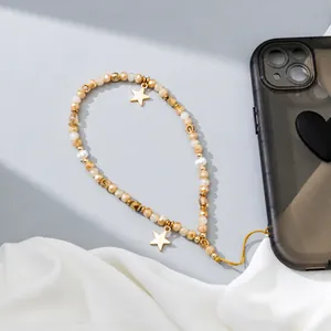 Colorful beaded phone strap with amber beads and gold star charms on silk background