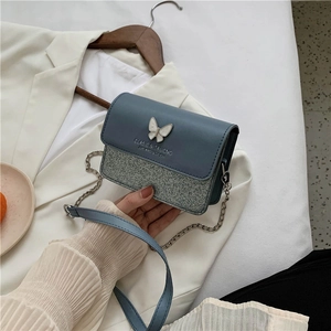 Elegant blue and silver glitter crossbody bag with a butterfly buckle and chain strap