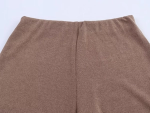 Detalle de primer plano de pantalones de punto marrón con cintura elástica y costura