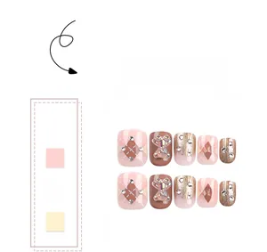 Detailed view of 3D bear charms, rhinestones and argyle patterns on pink square fake nails