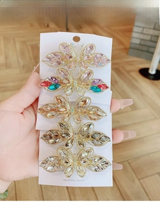 Detail of five crystal butterfly hair clips in varied colors on a handmade jewelry card