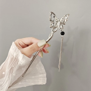Detailed shot of silver butterfly hair pin with tassels and calligraphy wing