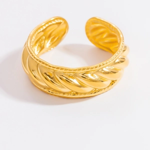 Detailed macro view of the gold twisted rope texture and bead edges on the open cuff bracelet