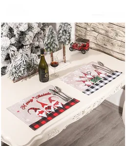 Detailed view of Christmas gnome placemats with plaid borders on a festive dinner table