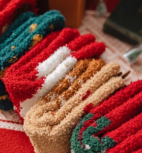 Macro shot of fuzzy coral fleece socks showing soft plush texture and holiday colors