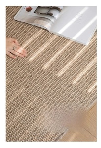 Detailed close-up of woven sisal-style rug showing mixed beige and hazelnut loop pile texture