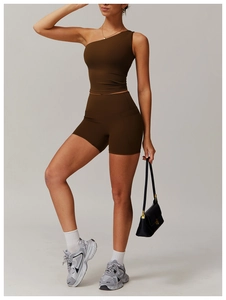 Détail du haut de yoga marron foncé à une épaule et du short de sport taille haute