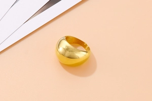 Detailed view of wide gold dome ring with high-polished mirror finish in a minimalist style