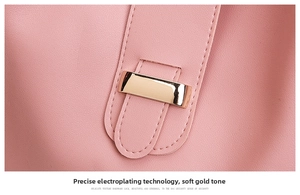 Detailed macro view of high-quality gold metal buckle on light pink leather handbag